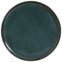Round teal ceramic plate on a white background