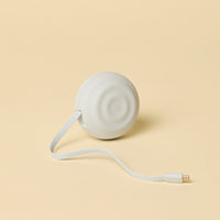 Retractable white charging cable on a beige background