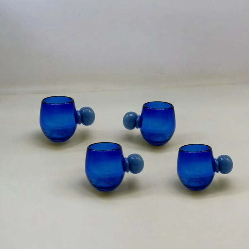 Set of four blue glass tumblers with spherical handles on a white background