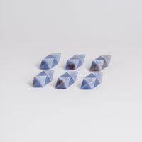 Set of six blue geometric stones on a light gray background