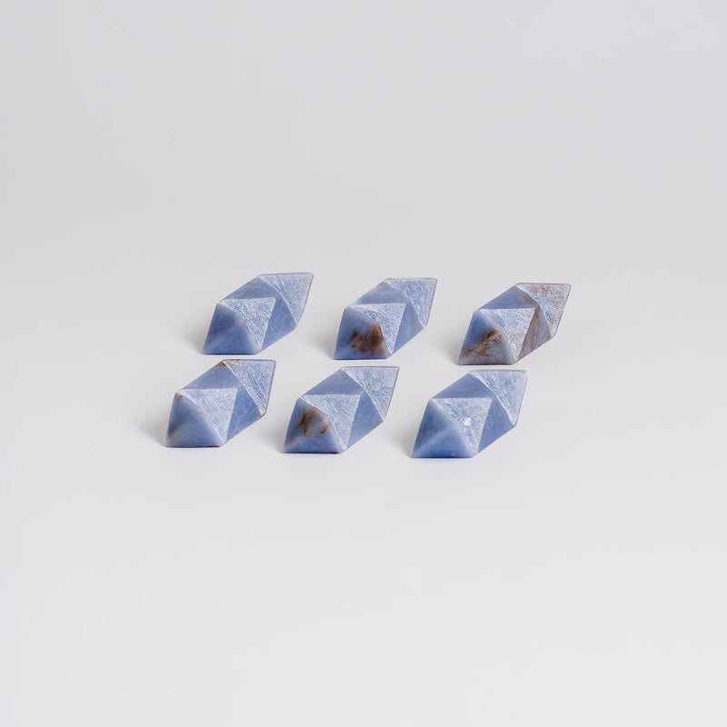 Set of six blue geometric stones on a light gray background