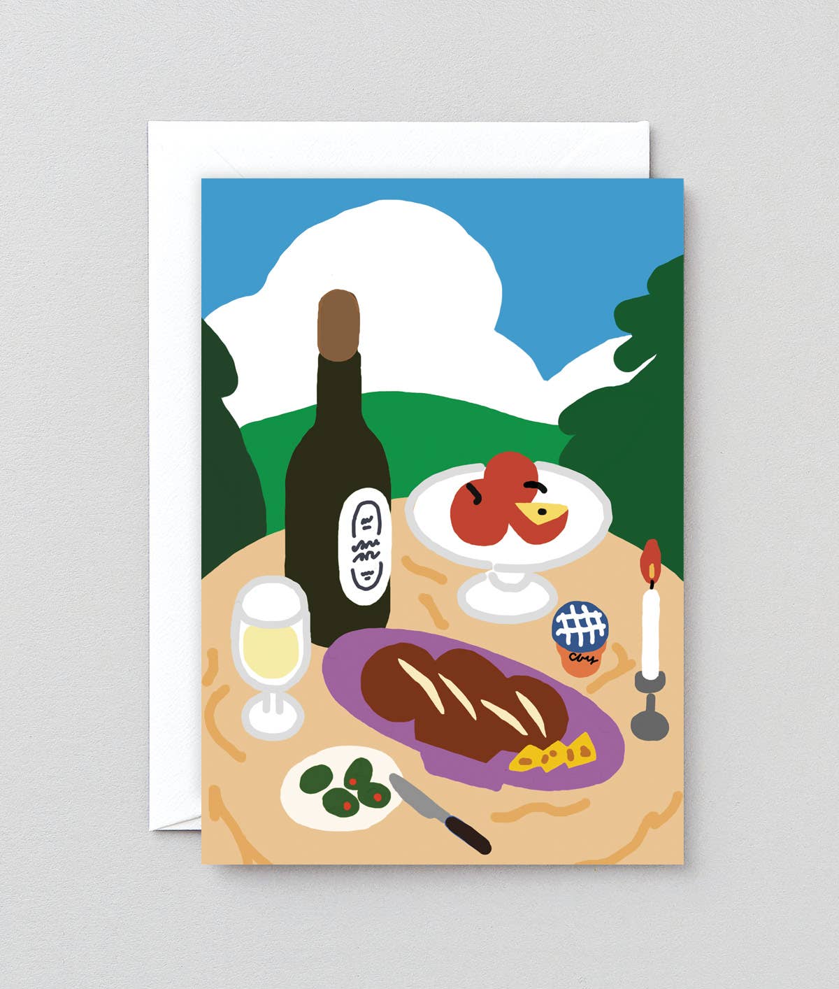Illustrated card with a meal scene including steak, wine, and fruit on a table with a scenic background.