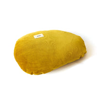 Yellow pillow with a brand label on a white background