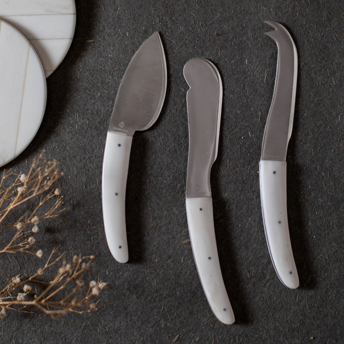 Set of 3 cheese knives on a dark surface
