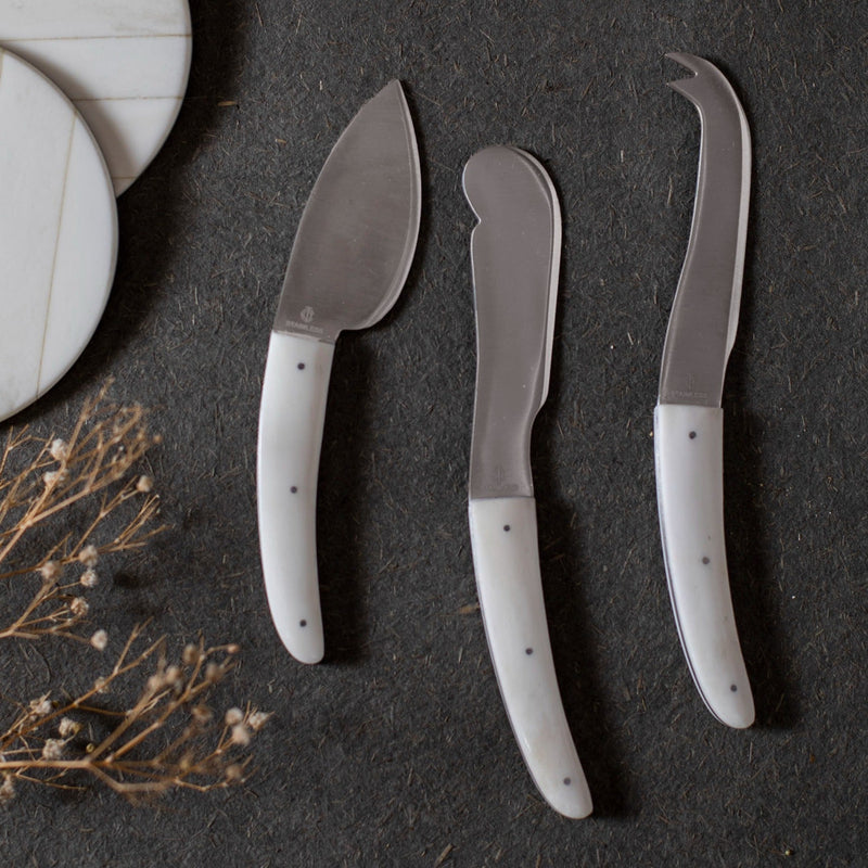 Set of 3 cheese knives on a dark surface