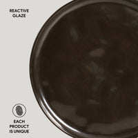 Close-up of a dark ceramic plate with 'Reactive Glaze' text on a light gray background.