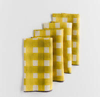 Set of yellow checkered napkins on a light gray background