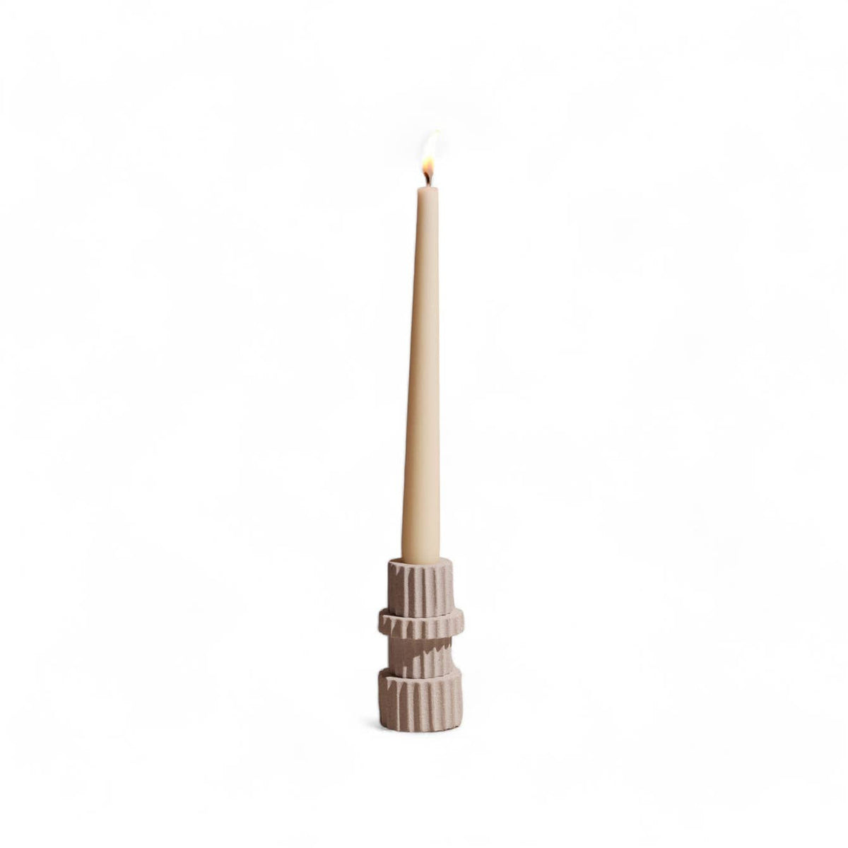 Taper candle in a decorative holder on a white background