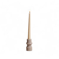 Taper candle in a decorative holder on a white background
