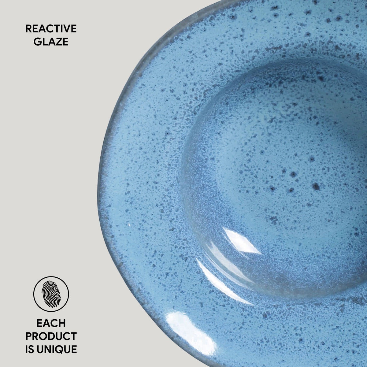 Blue ceramic bowl with reactive glaze on a light gray background