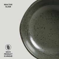 Close-up of a ceramic plate with reactive glaze on a light gray background