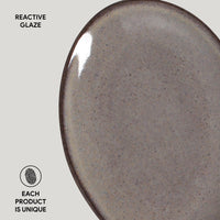 Close-up of a ceramic plate with reactive glaze on a light gray background