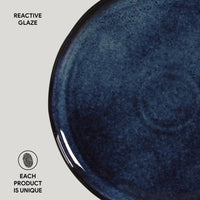 Close-up of a blue ceramic plate with reactive glaze on a light gray background