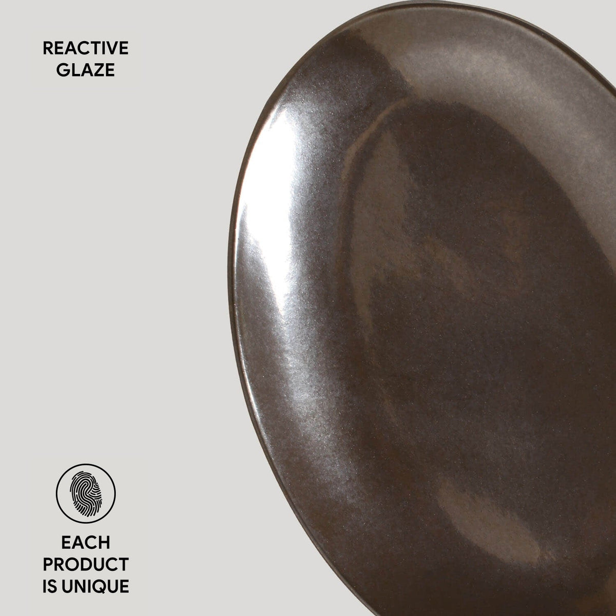 Dark metallic ceramic plate with 'Reactive Glaze' text on a light gray background