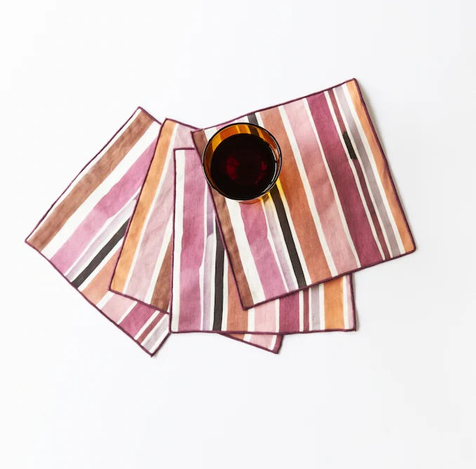 Set of striped cocktail napkins with a glass of red wine on a white background