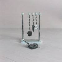 Metallic barware set with hanging tools on a light gray background