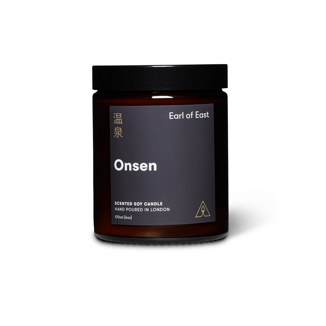 Dark glass jar scented soy wax candle with lid and branded label reading Earl of East Onsen
