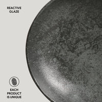 Close-up of a ceramic bowl with reactive glaze on a light gray background