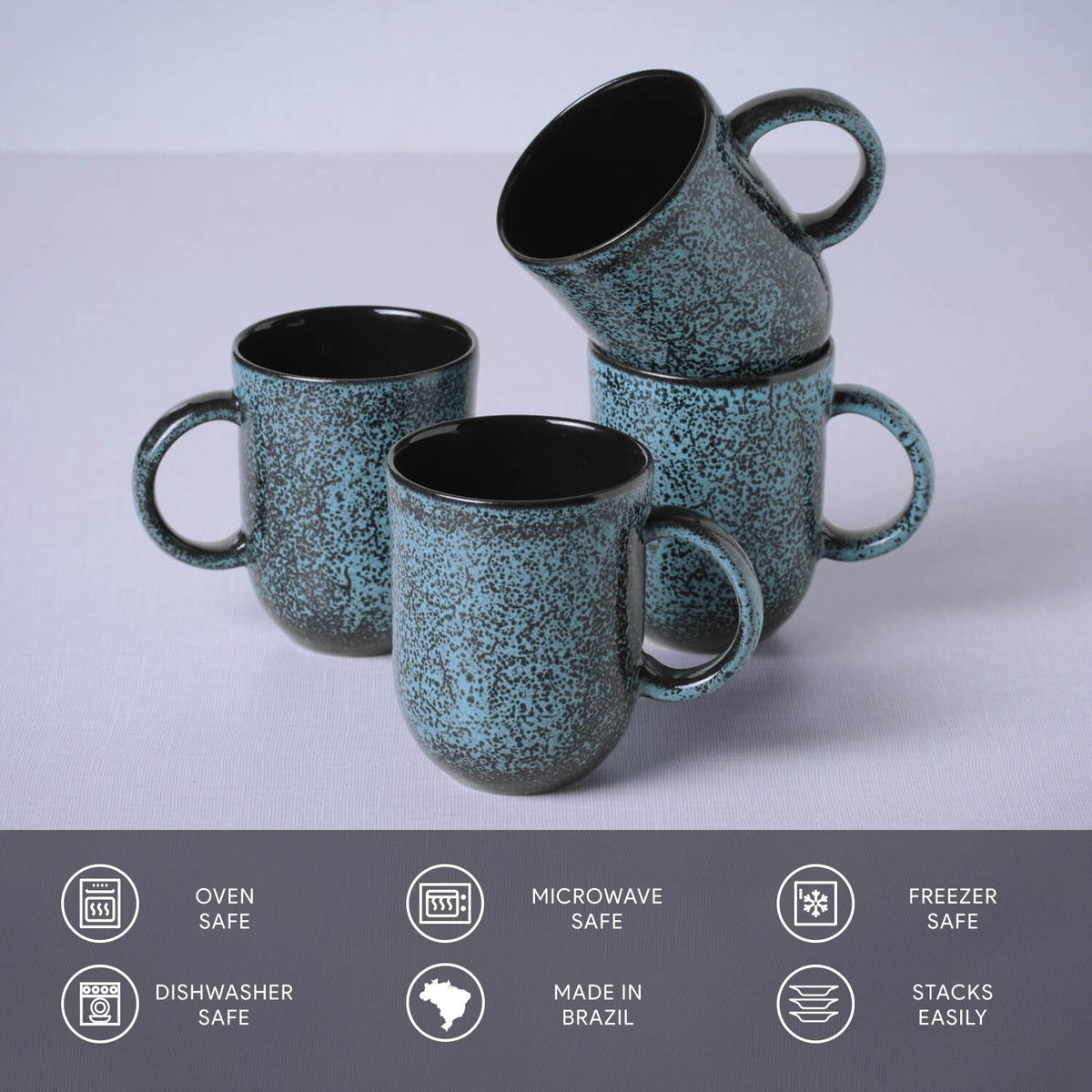 Set of four blue speckled mugs with black interior on a light gray background