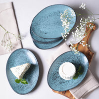 Set of blue ceramic plates with food on a light background