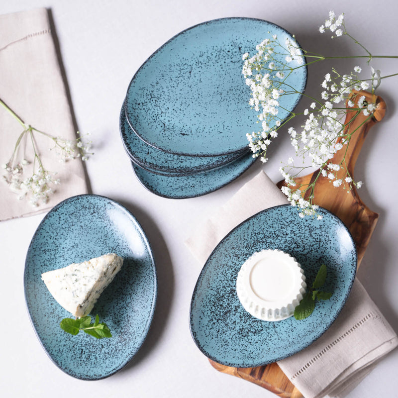 Set of blue ceramic plates with food on a light background