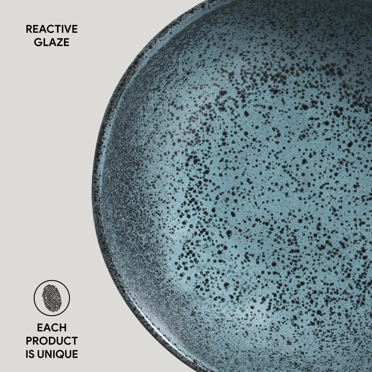 Blue ceramic plate with speckled glaze on a light gray background