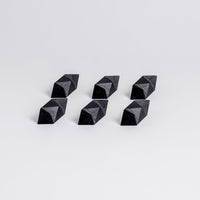 Six black geometric pyramid-shaped objects on a light gray background