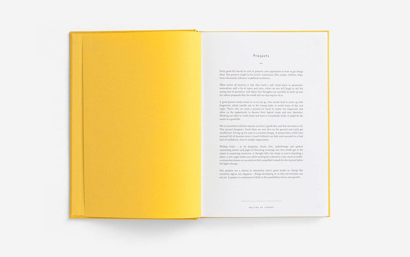 Open book with yellow cover and white pages on a light gray background