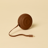 Brown circular device with a cable on a beige background