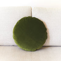 Green round pillow on a beige sofa