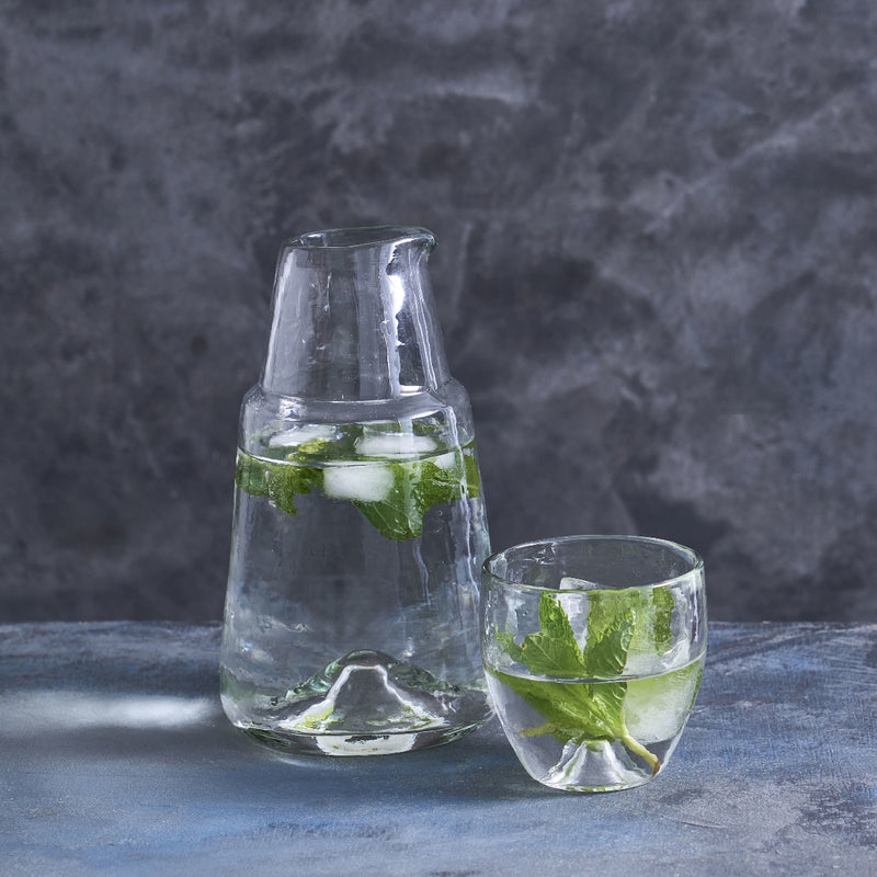 Pebbled Glass Bedside Carafe Set with mint water on a gray surface