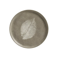 Round ceramic plate with a leaf design on a white background