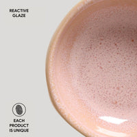 Close-up of a ceramic bowl with reactive glaze on a light gray background