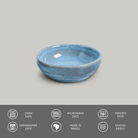 Blue ceramic bowl on a gray background with safety and feature icons at the bottom.