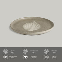 Ceramic plate with leaf design on a gray background