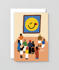 Card with illustration of people looking at a smiley face painting