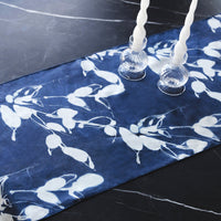 Blue table runner with white floral pattern on a black marble surface