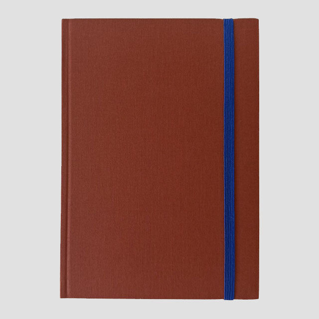 Brown notebook with a blue strap on a light gray background