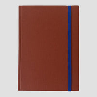 Brown notebook with a blue strap on a light gray background
