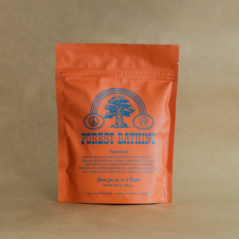 Orange bag of Forest Bathing Bath Soak with blue graphics and text on a Kraft paper background