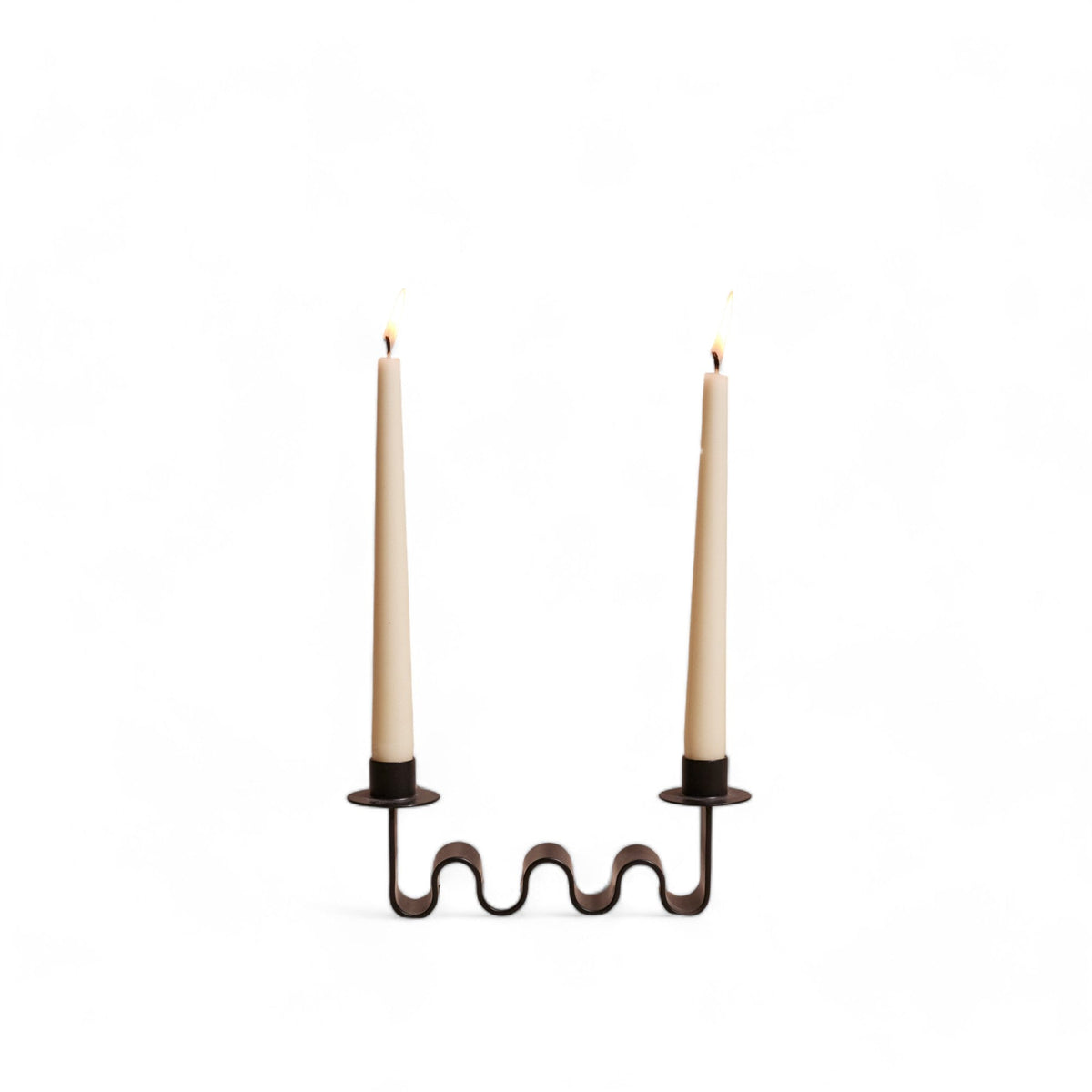 black metal wavy candle holder with two white candles on a white background