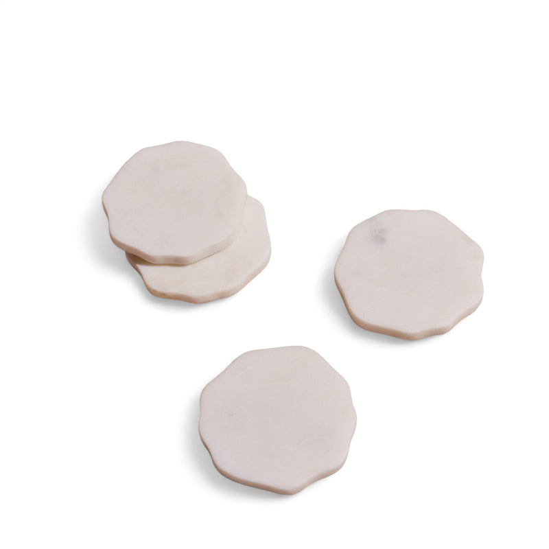 Four marble coasters with a subtle shape on a white background