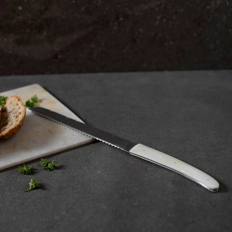 Bread knife on a cutting board and dark surface area