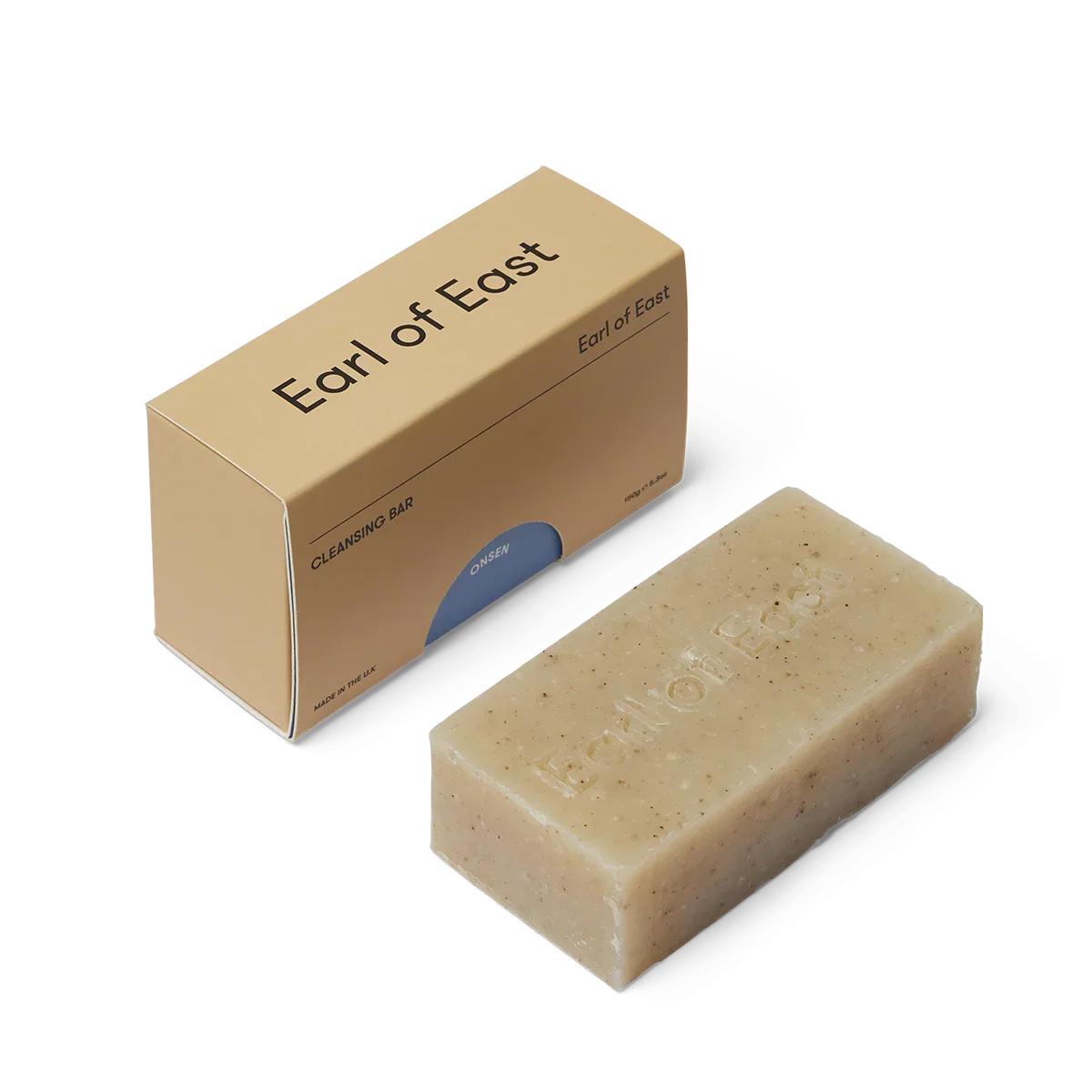 Beige cleansing bar of soap next to an 'Earl of East' branded cardboard box