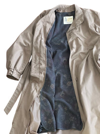 Taupe trench coat with pattern lining on a white background