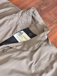 Closeup of the collar and label of a taupe London Fog trench coat