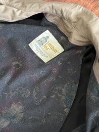 Close-up of a jacket lining with a 'London Fog' label on a wooden surface
