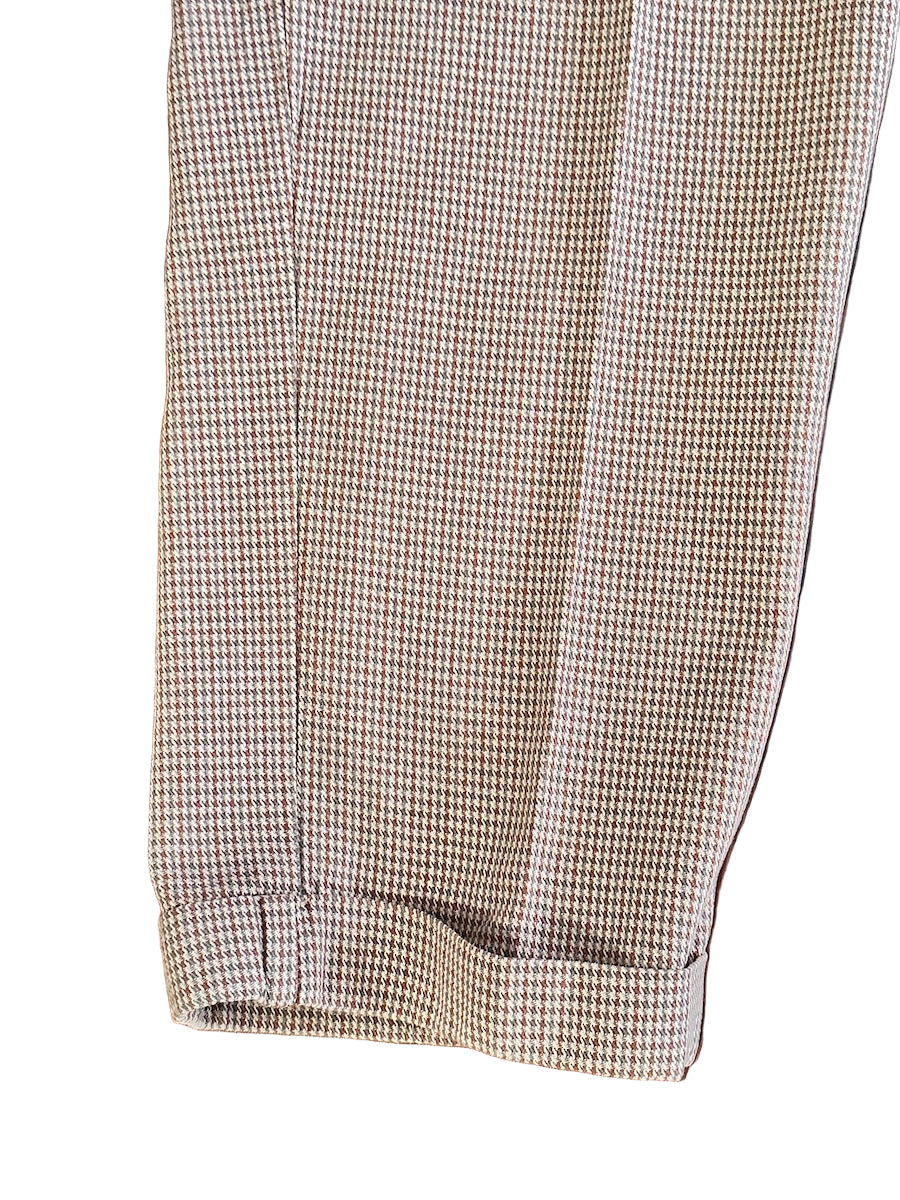 Houndstooth patterned pant leg on a white background