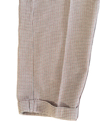 Houndstooth patterned pant leg on a white background