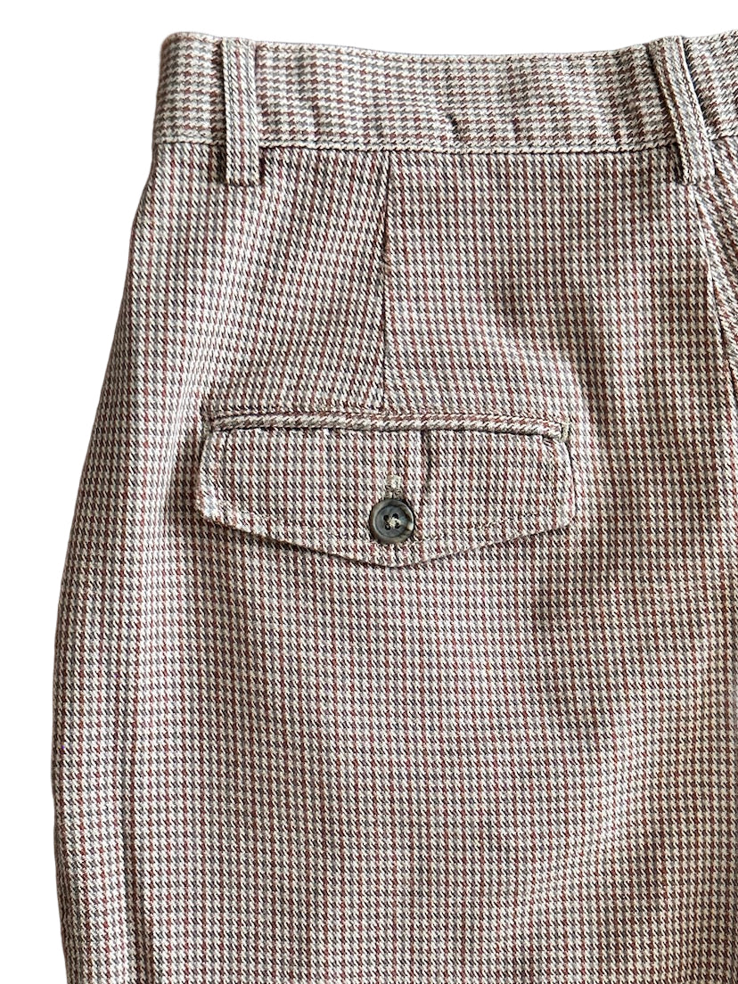 Houndstooth patterned pants with a pocket on a white background